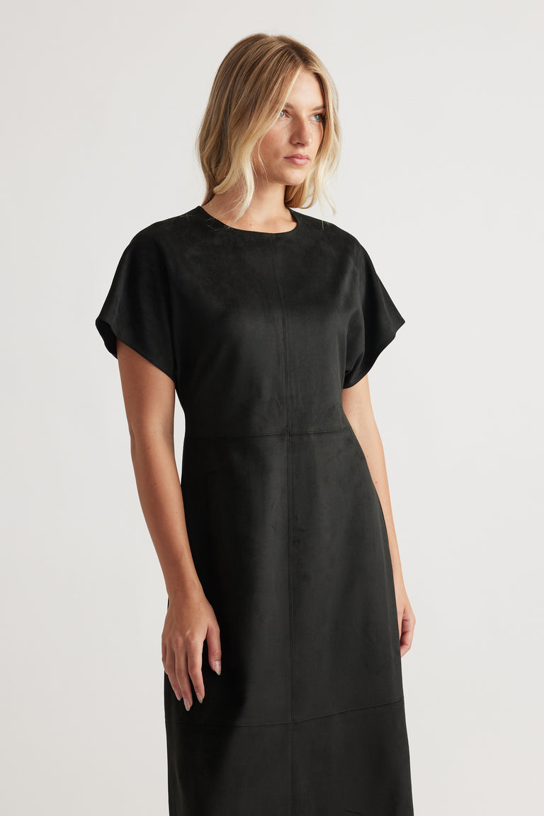 Woman wearing Clara Faux Suede Midi Dress in black with short sleeves and a subtle seam detail for a sleek, modern style