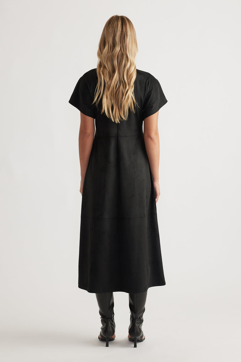 Back view of Clara Faux Suede Midi Dress in sleek black with short sleeves, styled with black heeled boots for a modern look