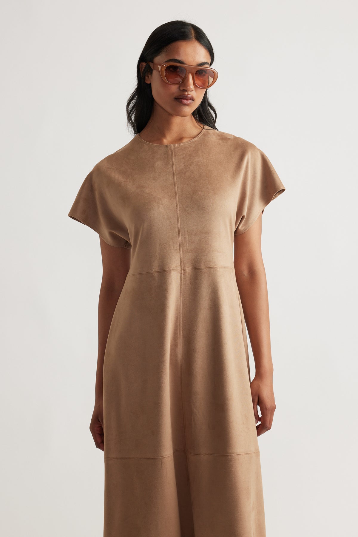 Woman wearing a soft camel Clara Faux Suede Midi Dress with short sleeves and a relaxed fit, styled with tinted sunglasses