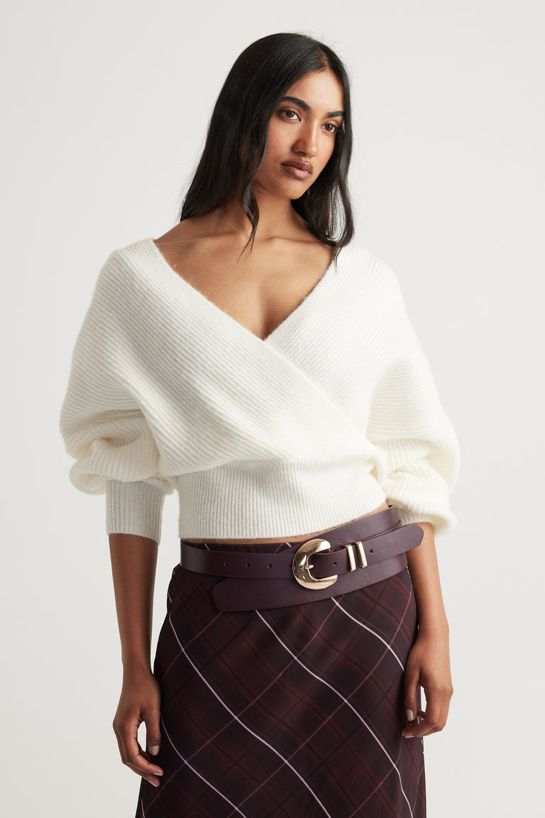 Harper Crossover Jumper in soft white knit with a deep V-neck and relaxed fit styled with plaid skirt by Decjuba Australian brand