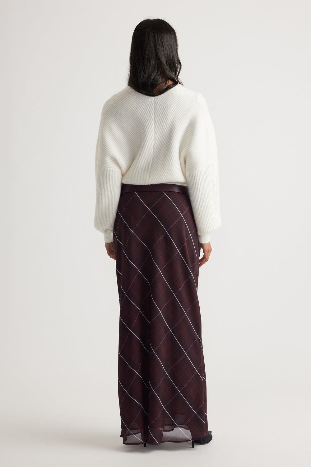 Back view of Harper Crossover Jumper in soft white knit paired with a flowy checkered skirt by Decjuba Australian brand