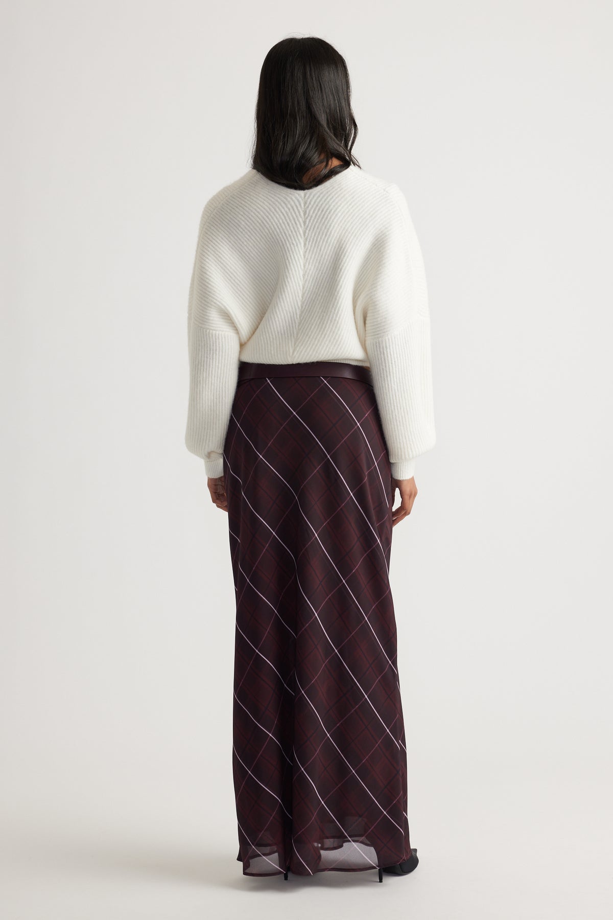 Back view of Harper Crossover Jumper in soft white knit paired with a flowy checkered skirt by Decjuba Australian brand
