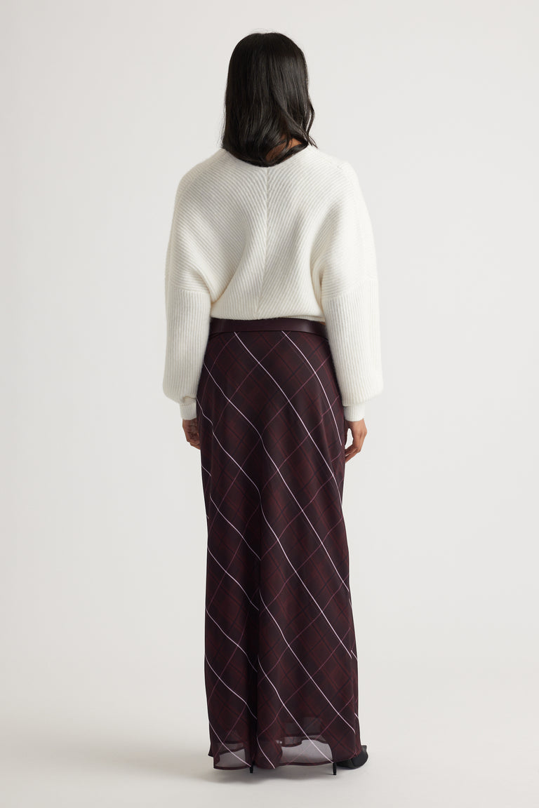 Back view of Harper Crossover Jumper in soft white knit paired with a flowy checkered skirt by Decjuba Australian brand