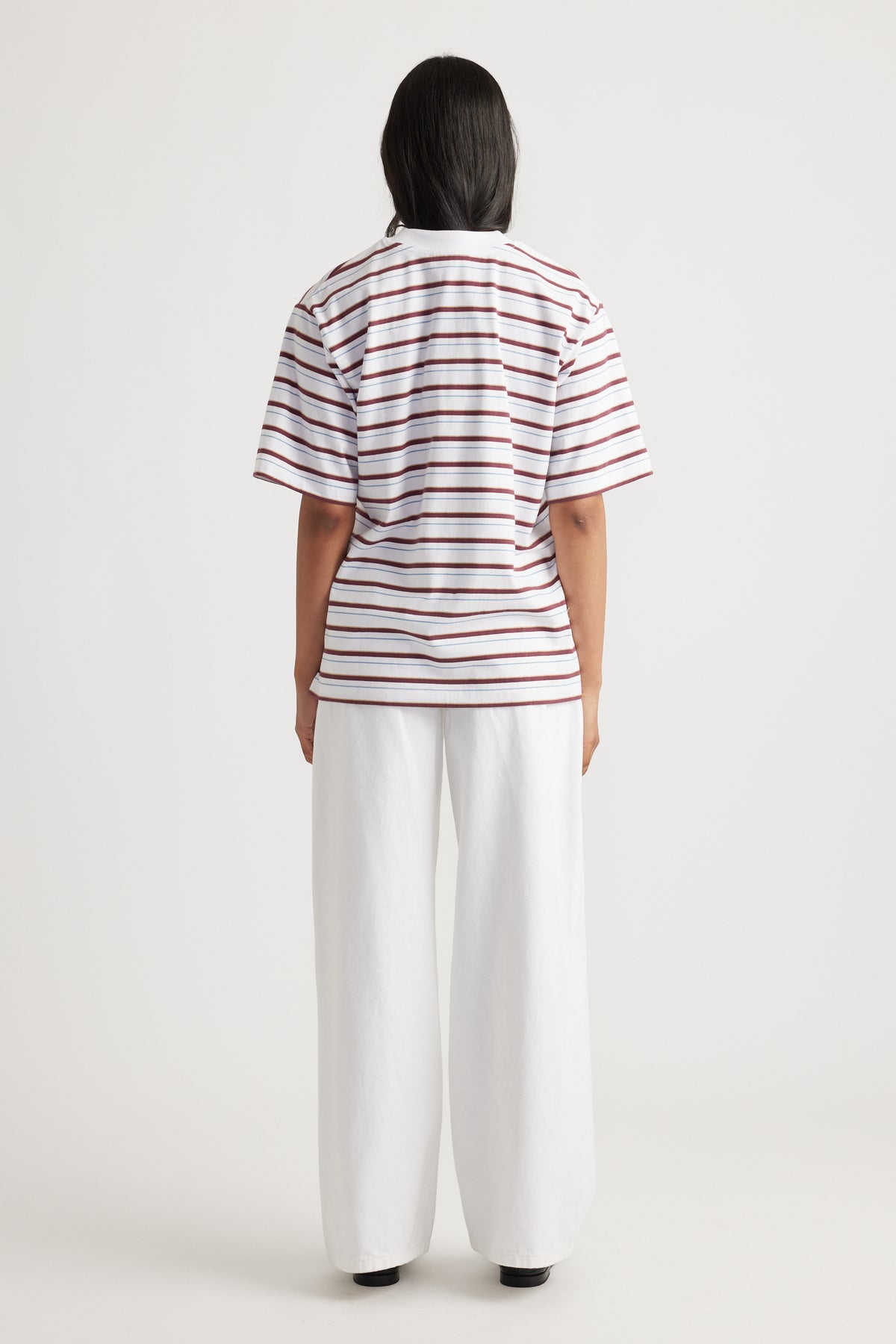 Woman shown from behind wearing Isabella Oversized Stripe Tee with loose fit and horizontal rust and white stripes by DECJUBA