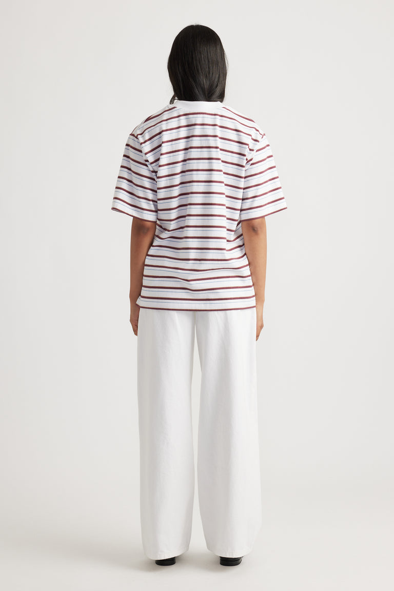 Woman shown from behind wearing Isabella Oversized Stripe Tee with loose fit and horizontal rust and white stripes by DECJUBA
