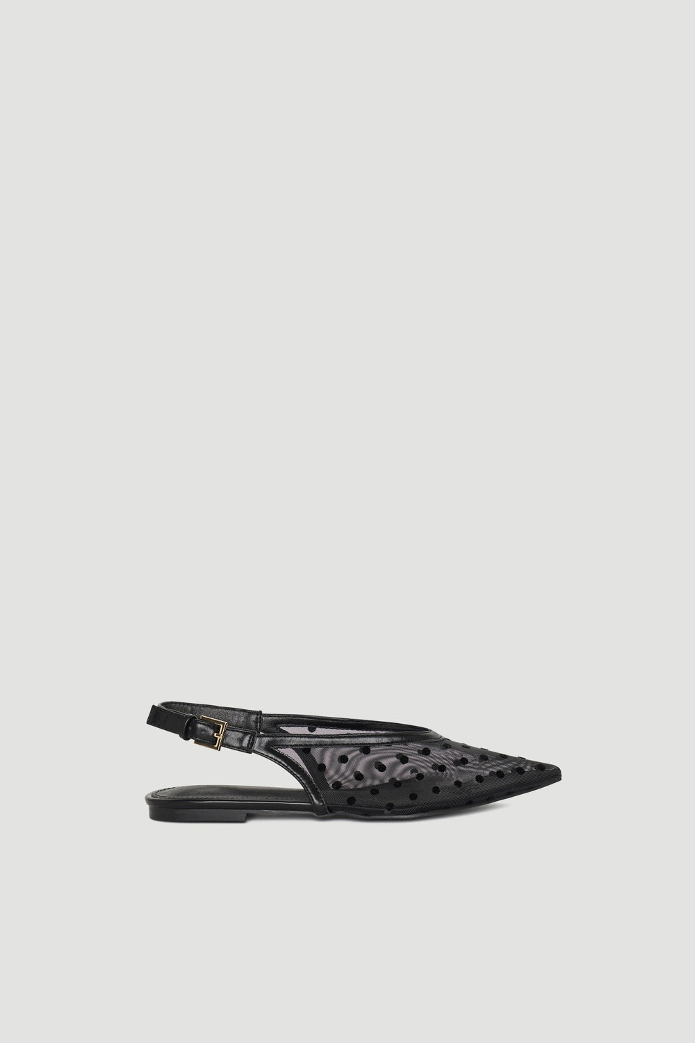 Black pointed slingback shoe with polka dot mesh and adjustable buckle strap for chic, lightweight wear.