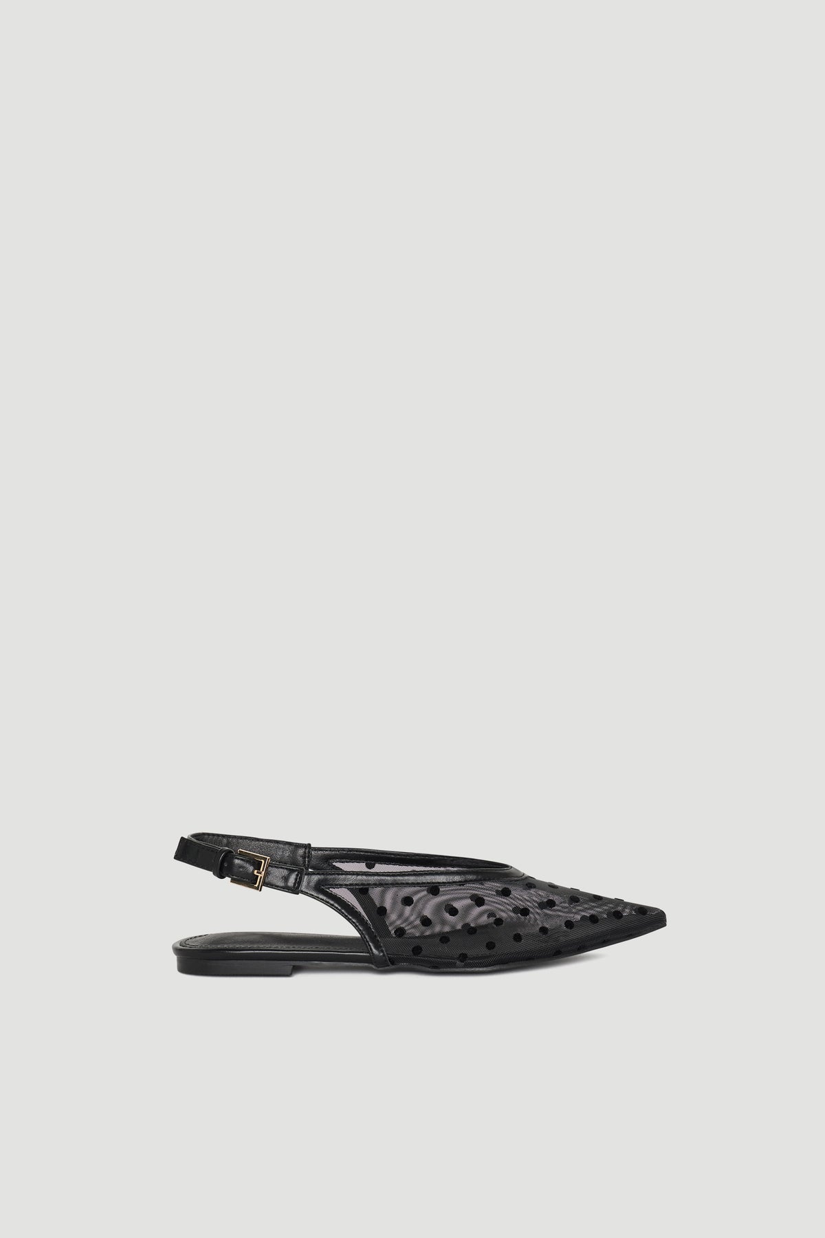 Black pointed slingback shoe with polka dot mesh and adjustable buckle strap for chic, lightweight wear.