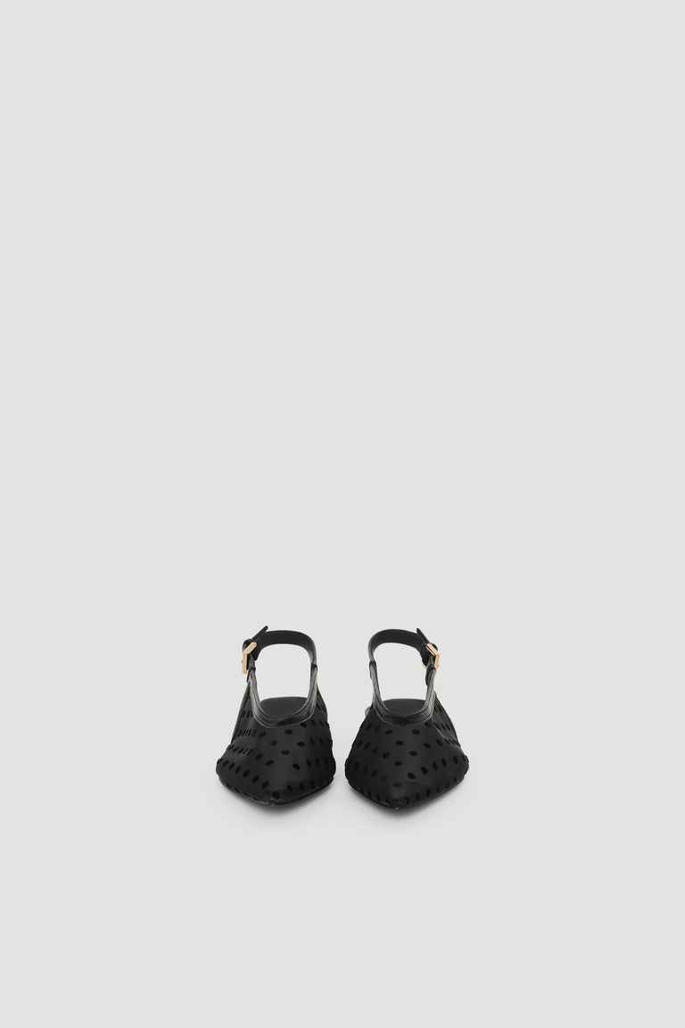 Black slingback flats with pointed toe and subtle polka dot texture, featuring an adjustable buckle strap for a chic finish