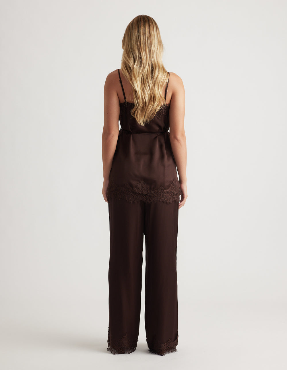 Back view of a rich mocha silky camisole with delicate lace trim paired with matching wide-leg pants