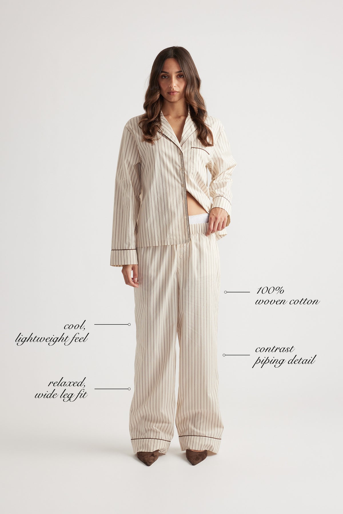 Woman wearing relaxed wide leg sleep pants in woven cotton with subtle vertical stripes and contrast piping trim