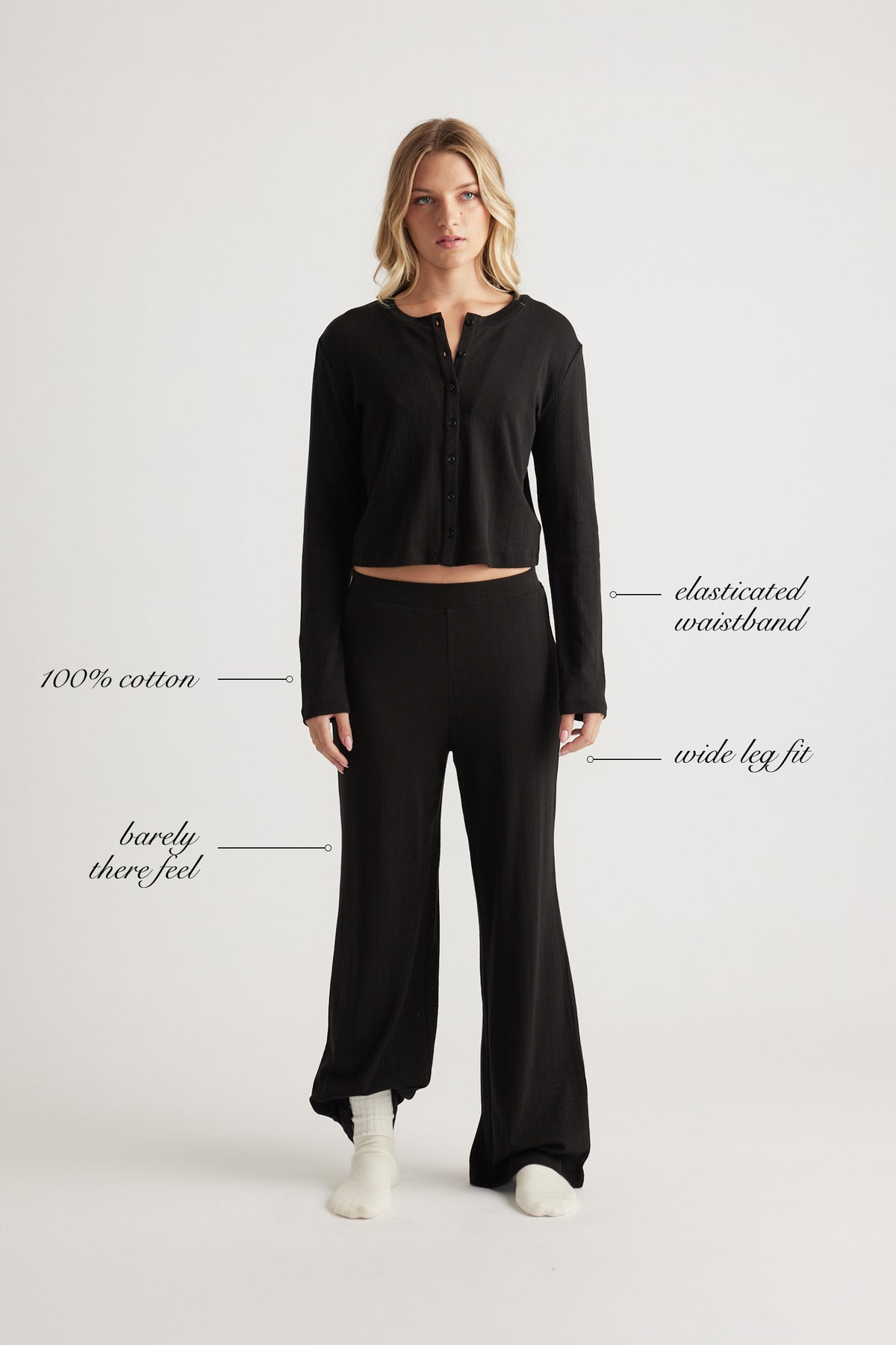 Woman wearing black wide leg pants with elastic waistband and matching long sleeve cropped top in soft cotton fabric