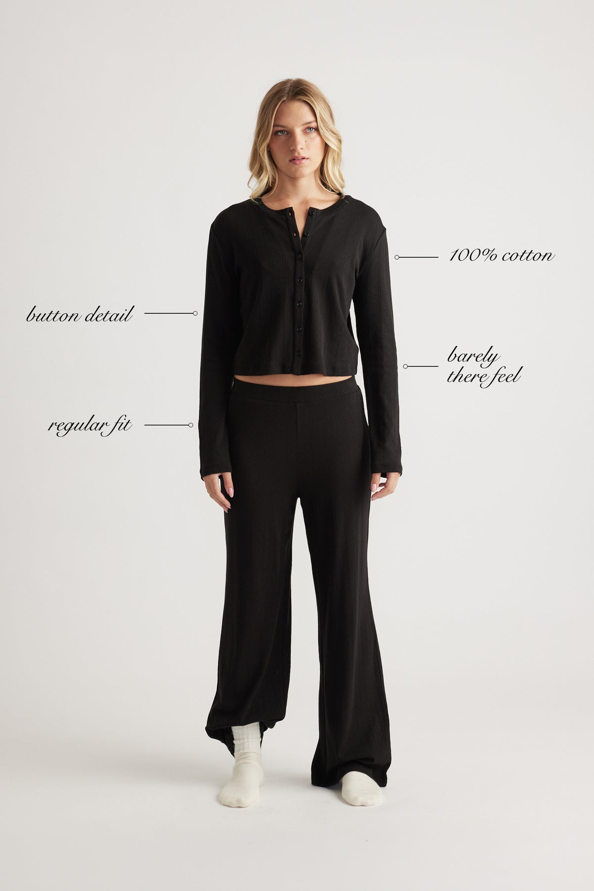 Woman wearing black button-up sleep top with long sleeves in soft cotton fabric and relaxed fit paired with matching pants