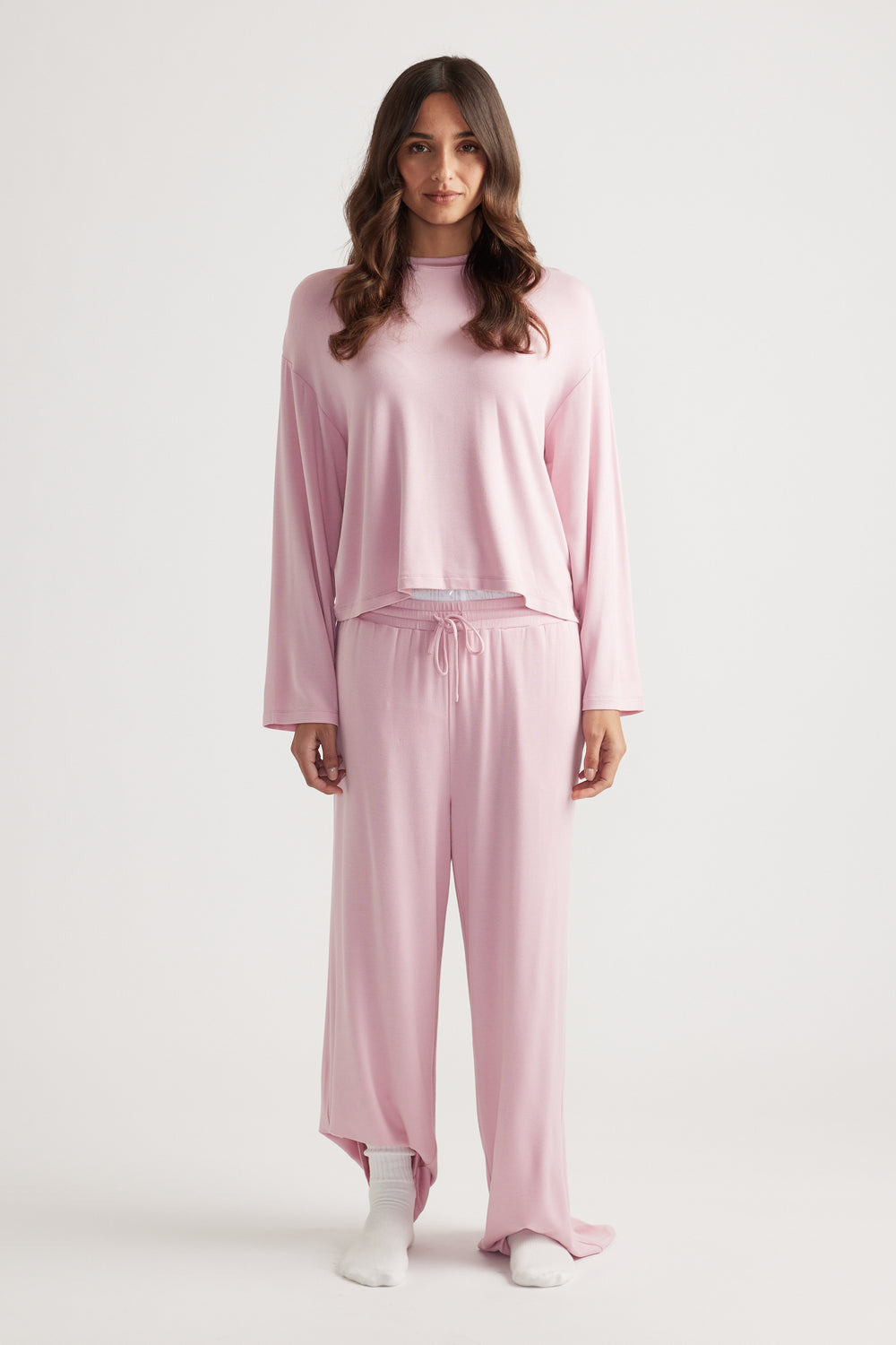 Woman wearing soft pink relaxed sleep jersey long sleeve top and matching wide leg lounge pants for cozy comfort
