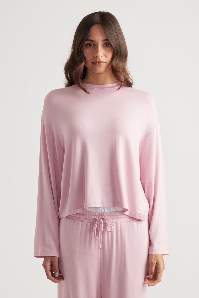 Woman wearing a relaxed fit sleep jersey long sleeve top in soft wildberry pink with matching lounge pants