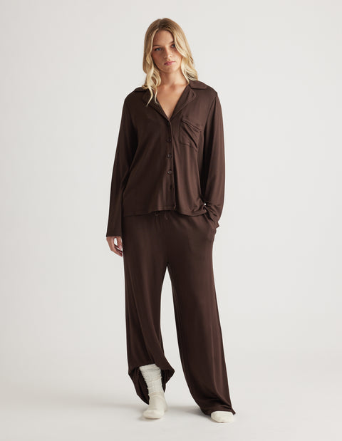Woman wearing a relaxed fit sleep button through shirt and matching wide leg pants in rich chocolate brown with soft fabric