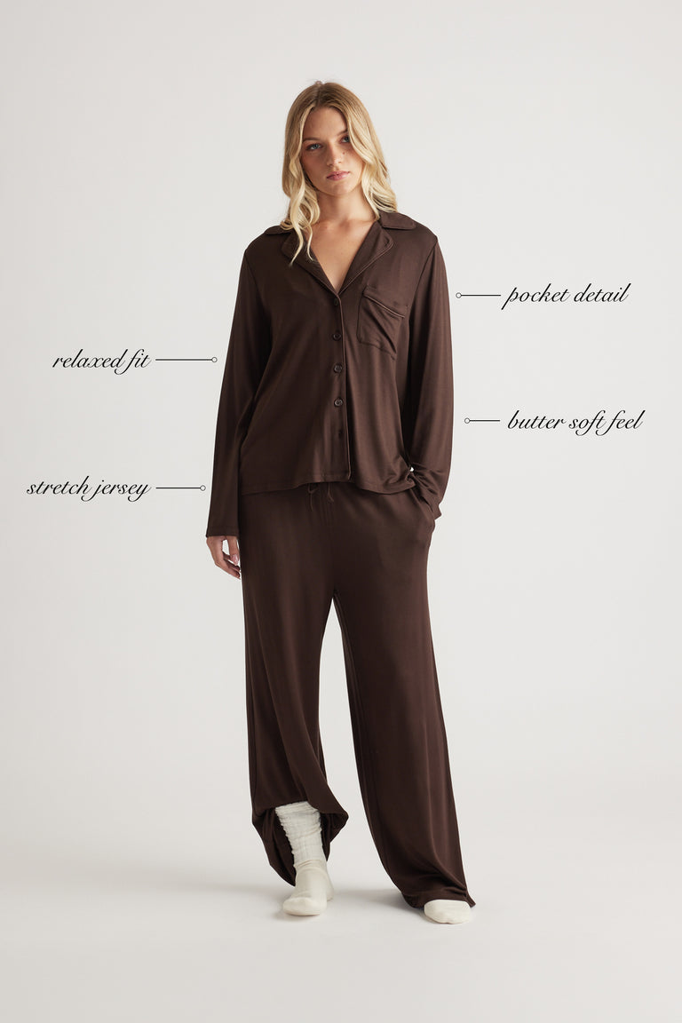 Woman wearing relaxed fit chocolate brown button-up shirt with pocket detail and matching wide leg pants