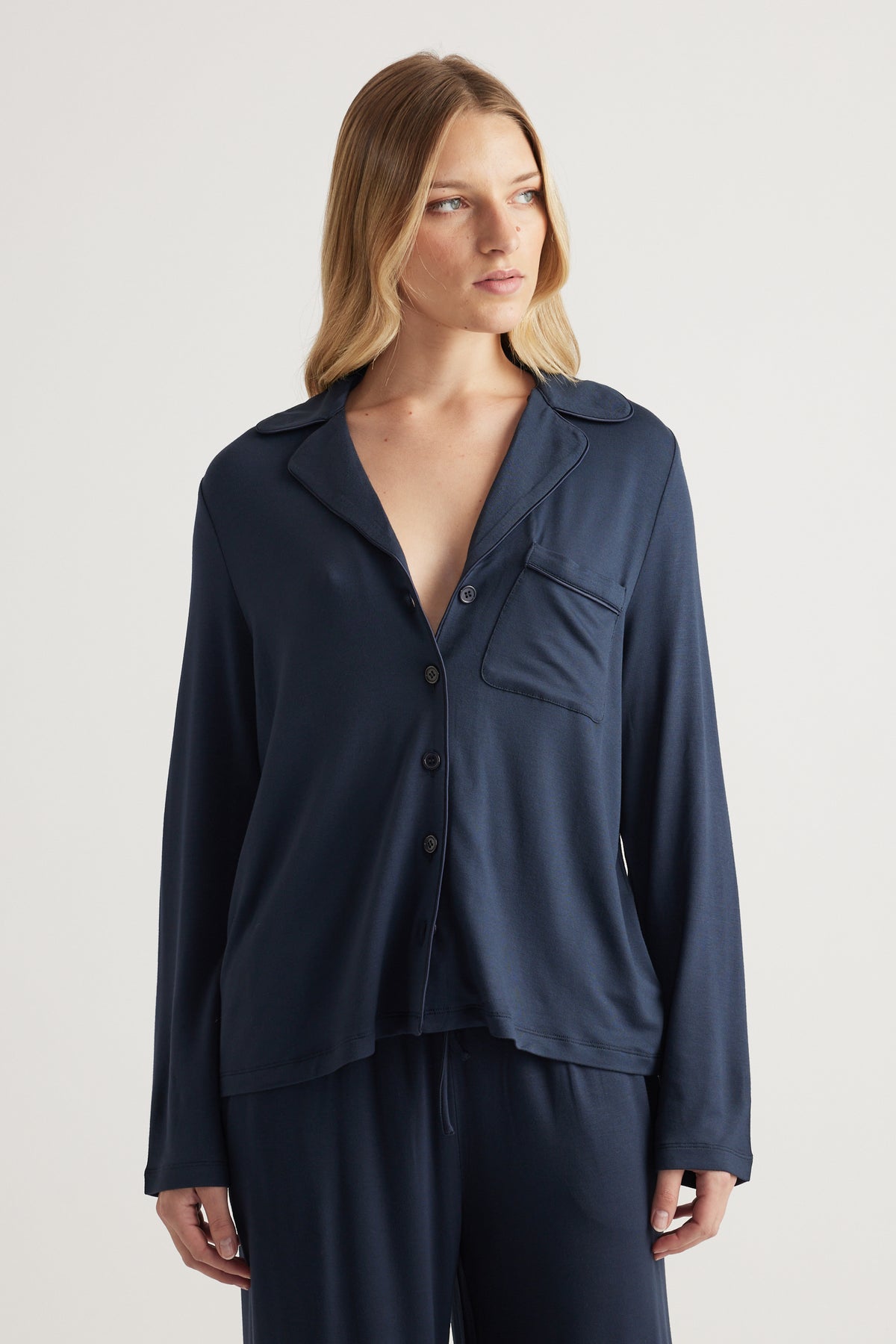 Woman wearing a navy button through shirt with chest pocket and matching drawstring pants