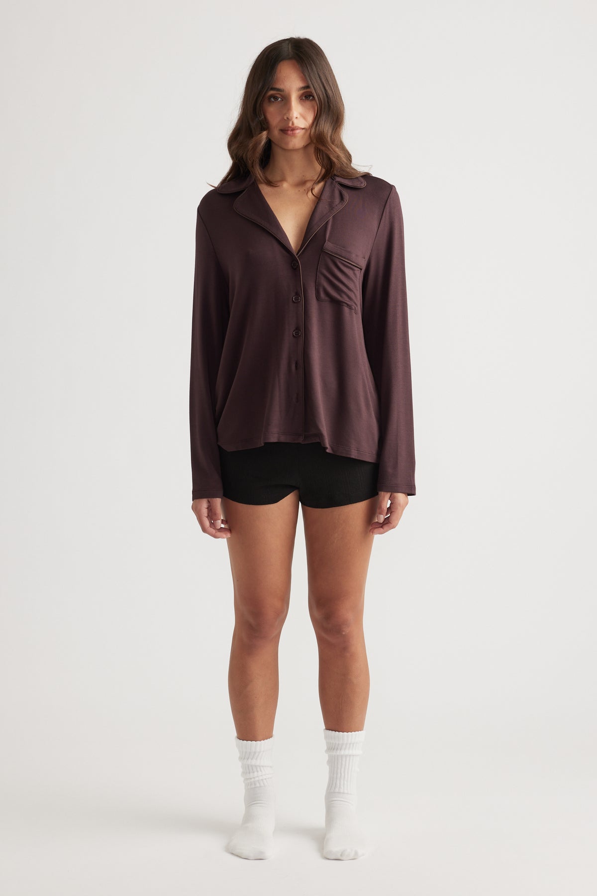 Woman wearing a relaxed fit sleep button through shirt in rich rhubarb with long sleeves and a chest pocket detail
