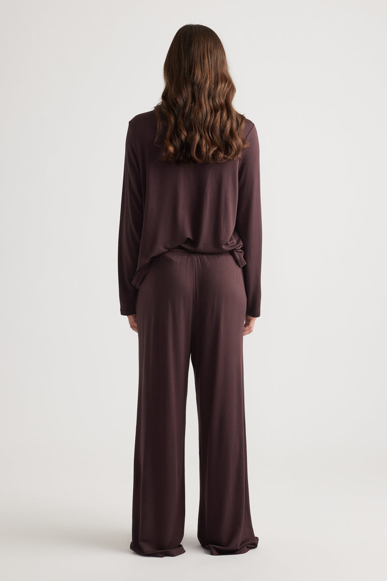 Woman wearing relaxed fit sleep button through shirt and matching wide leg pants in deep rhubarb color for casual comfort