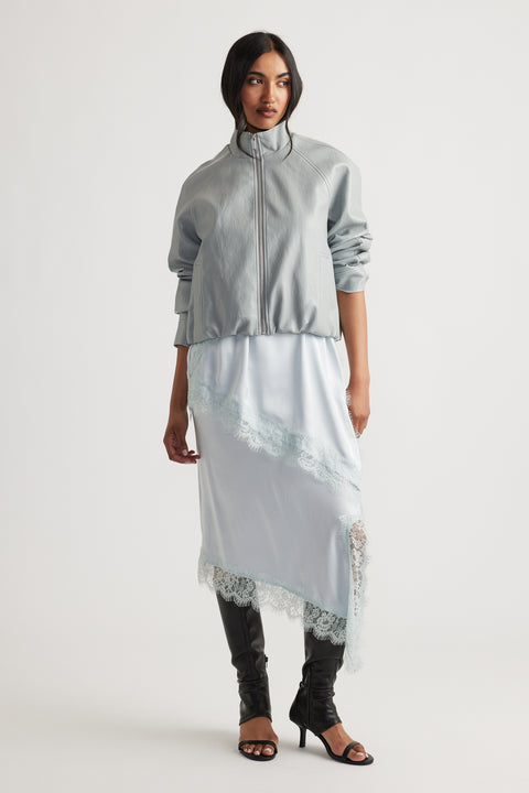 Woman wearing Grace Faux Leather Bomber in soft grey paired with lace-trimmed slip dress and black heeled boots by DECJUBA Australian brand