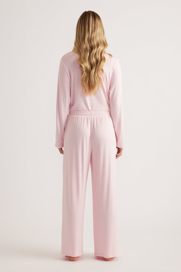 Woman wearing pink wide-leg jersey pants with a matching long-sleeve top