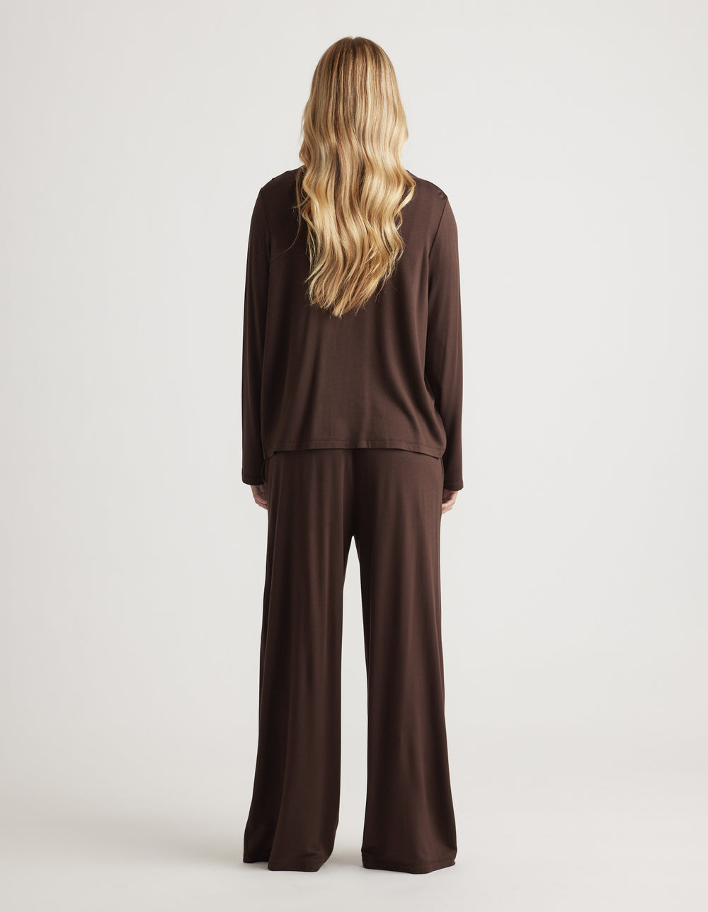 Woman with long loose hair wearing a relaxed chocolate brown lounge set with wide-leg pants from the back view