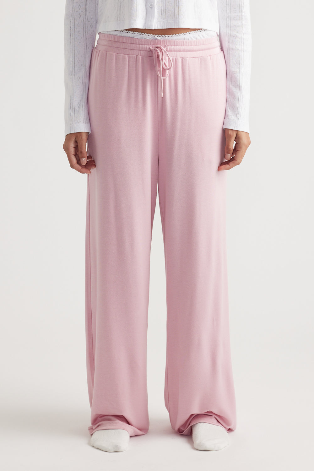 Light pink wide leg pants in soft sleep jersey fabric with elastic waistband and drawstring for relaxed, breathable comfort