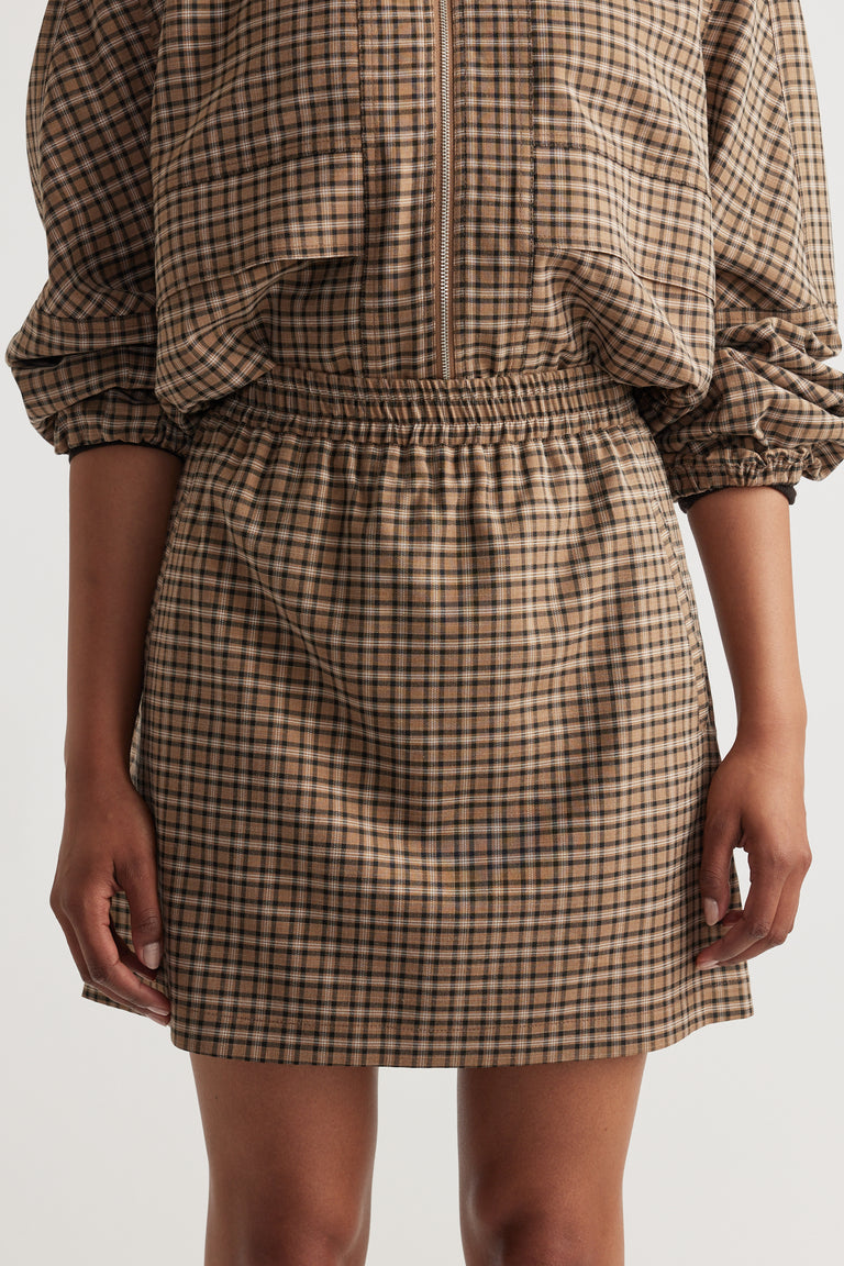 Woman wearing Violet Check Mini Skirt in warm brown check pattern styled with matching top for a cohesive look by DECJUBA