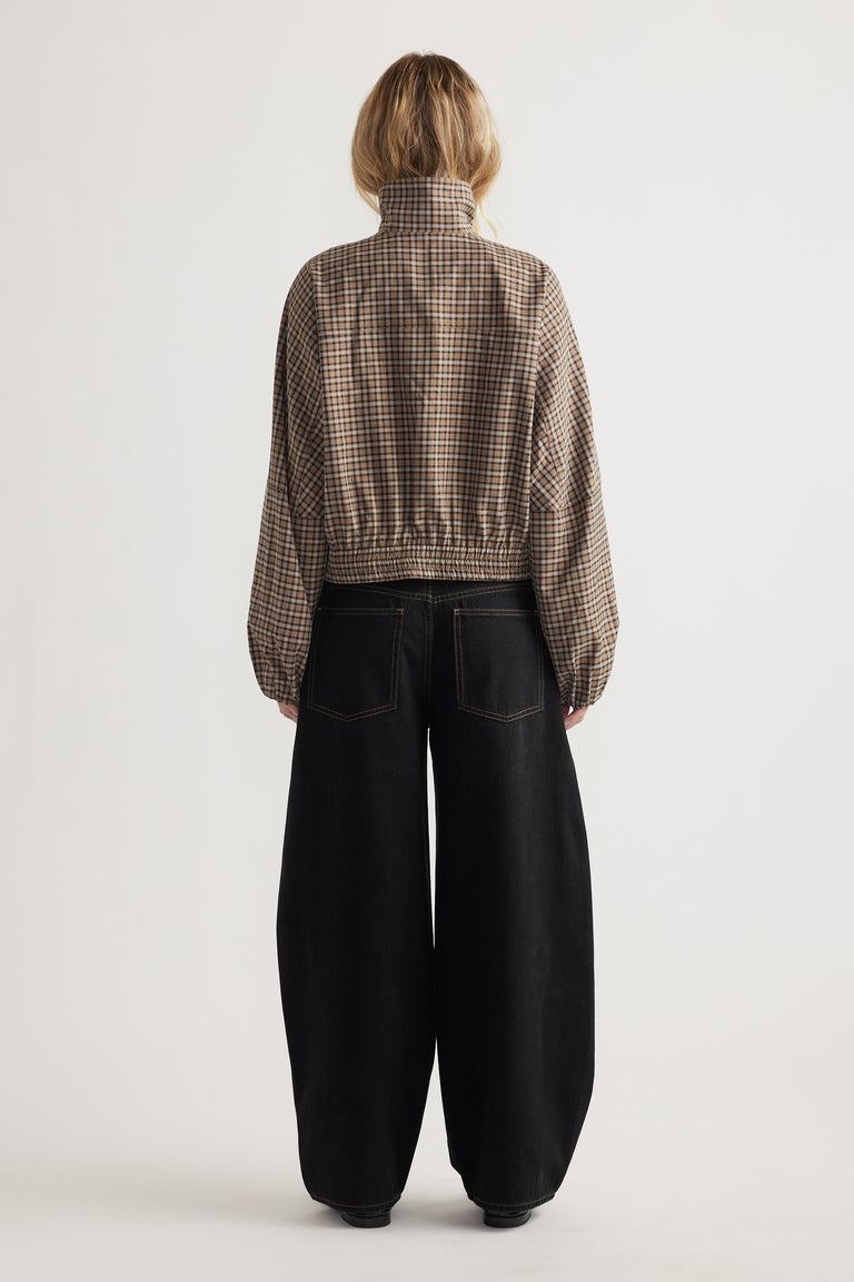 Rear view of woman wearing a cropped zip-up check jacket with elasticated hem and wide-leg black pants