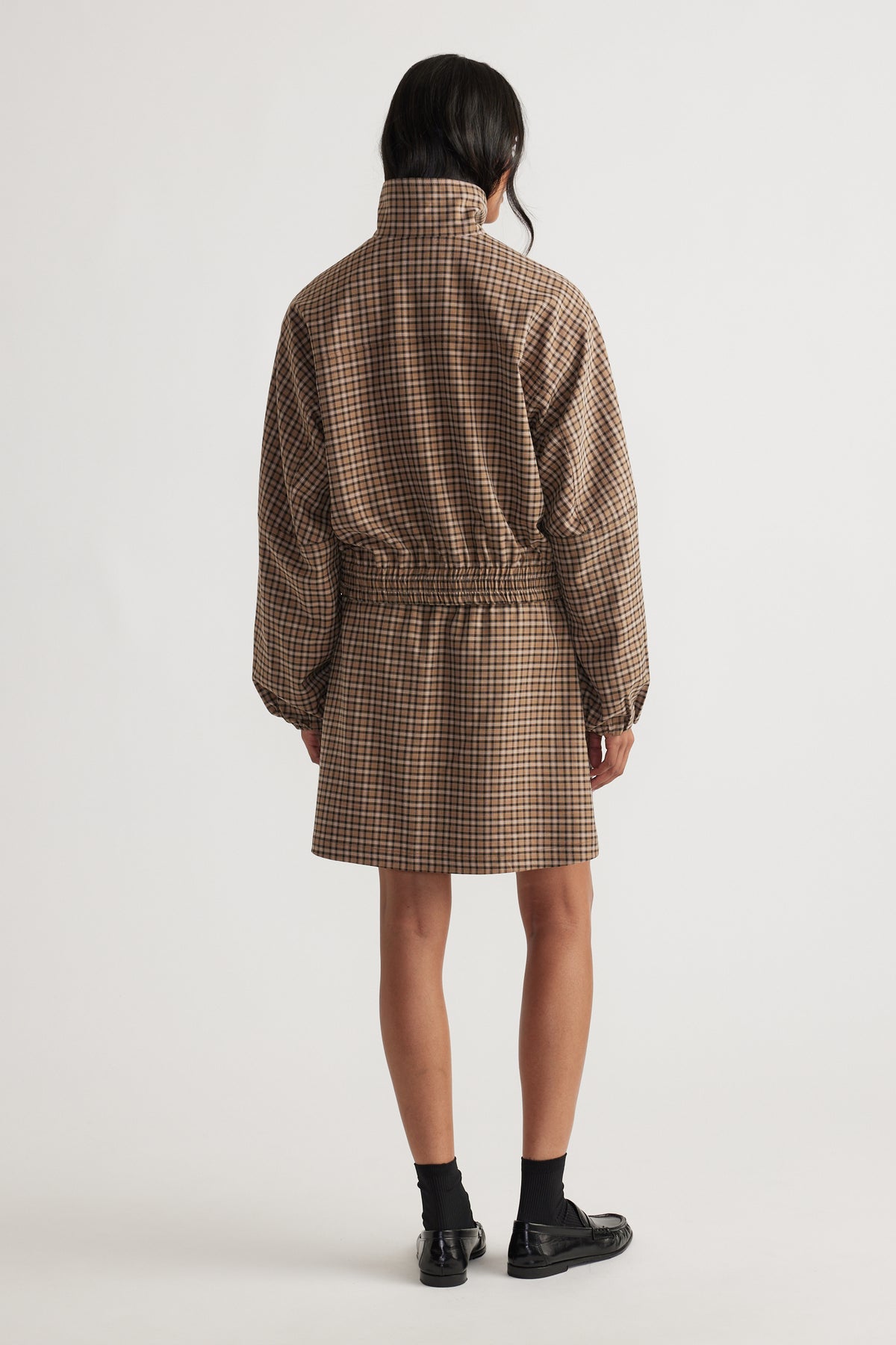 Back view of Violet Check Mini Skirt styled with a coordinating check jacket, featuring a relaxed elastic waistband fit.