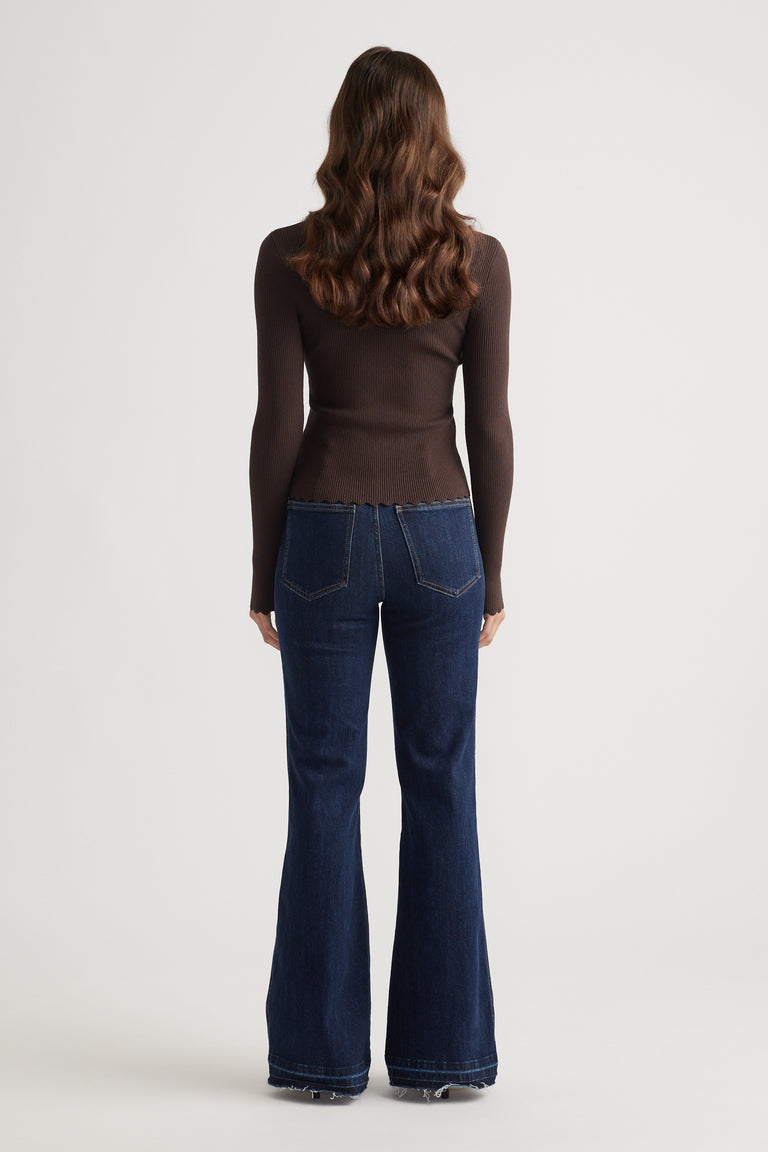 Back view of slim-fit dark brown top paired with high-waisted dark blue flared denim jeans for a sleek casual look