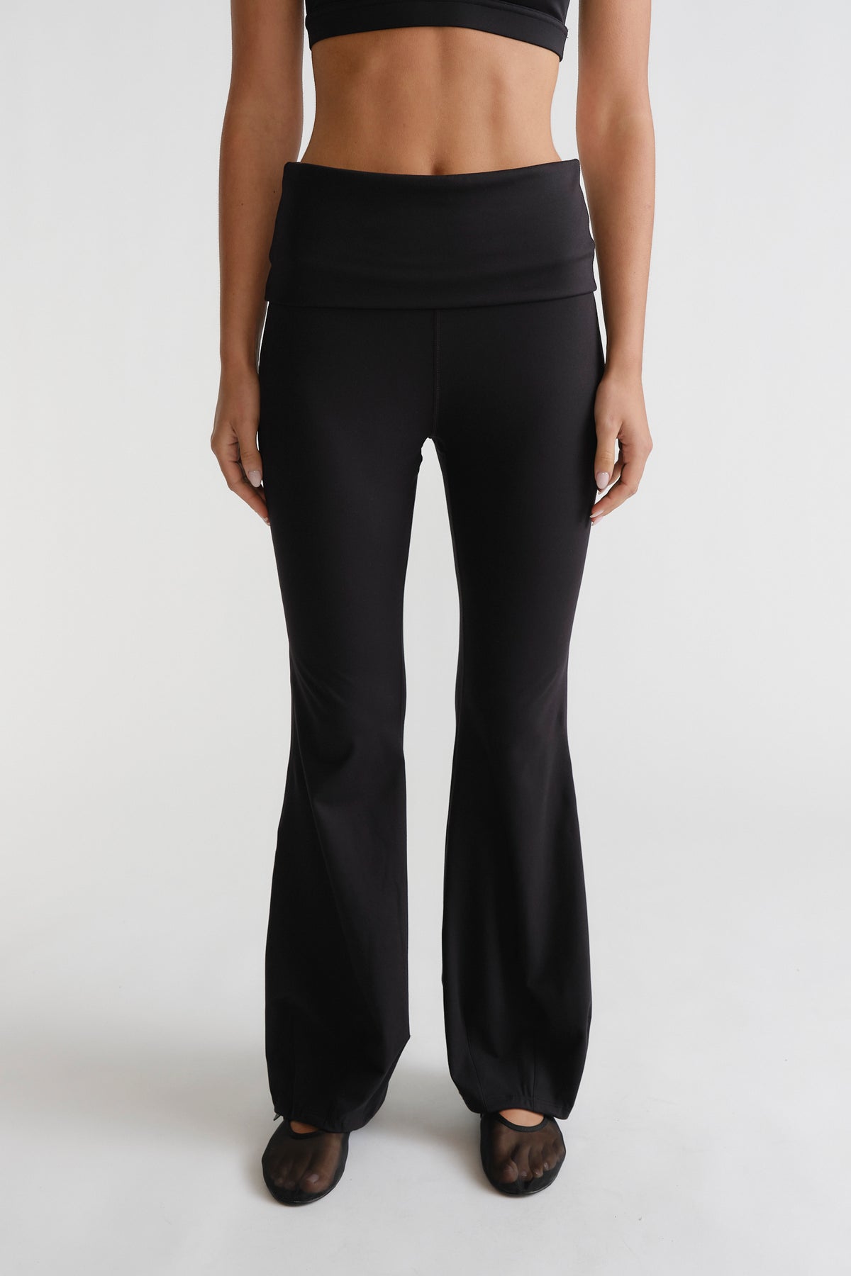 Front view of woman wearing black D-Luxe Flare Legging with a high waistband and fitted flare silhouette by DECJUBA