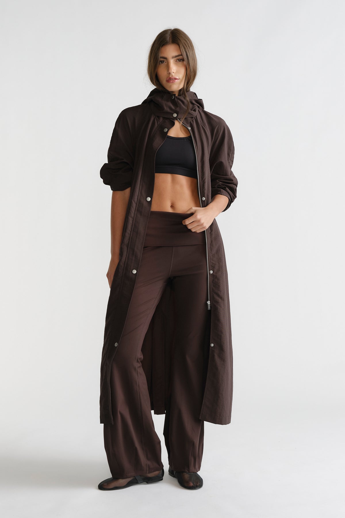 Woman wearing cocoa brown D-Luxe Flare Legging with a high waistband and relaxed flare silhouette paired with a long coat