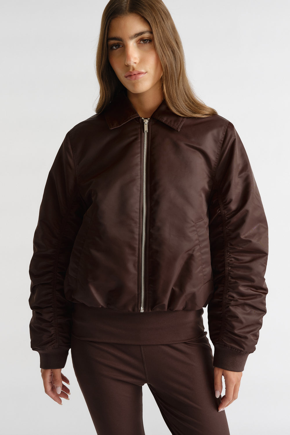 Front view of woman wearing D-Luxe Collared Bomber Jacket in rich cocoa brown with ruched sleeves and matching bottoms