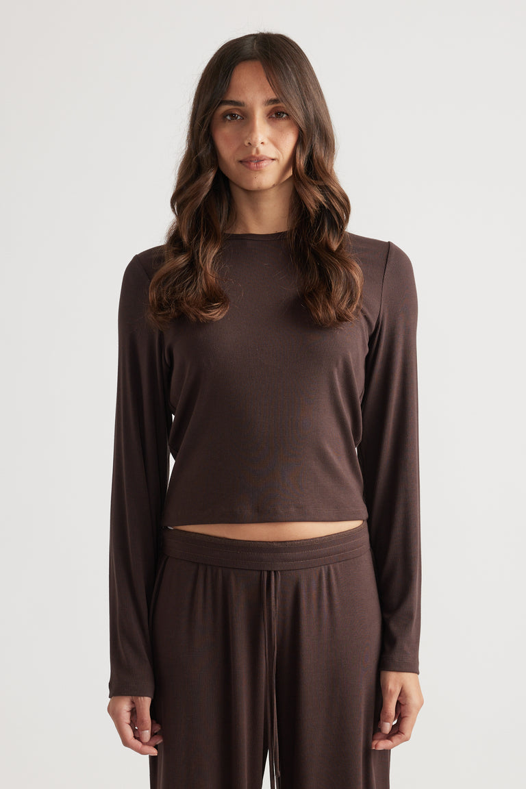 Woman modeling a dark brown ribbed long sleeve top with relaxed fit and matching wide-leg lounge pants