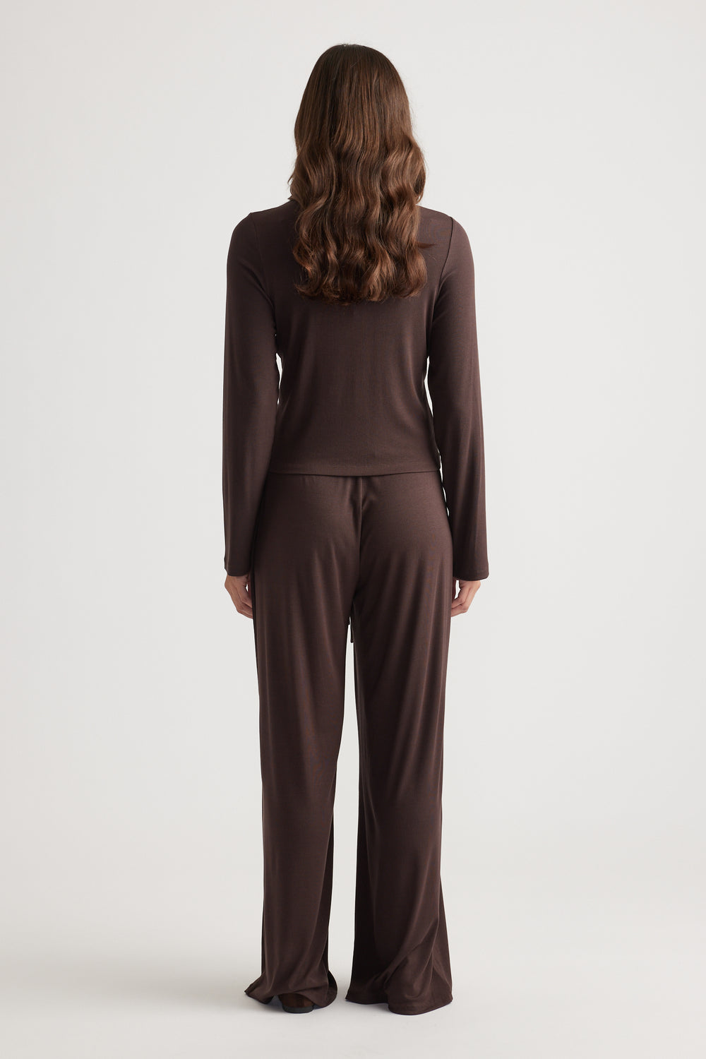 Woman wearing relaxed dark chocolate sleepwear set with long sleeves and wide-leg pants in soft fabric