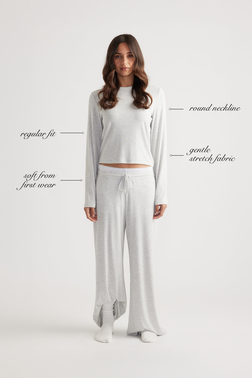 Woman wearing a light grey ribbed long sleeve top with round neckline and relaxed wide leg pants for laid-back comfort