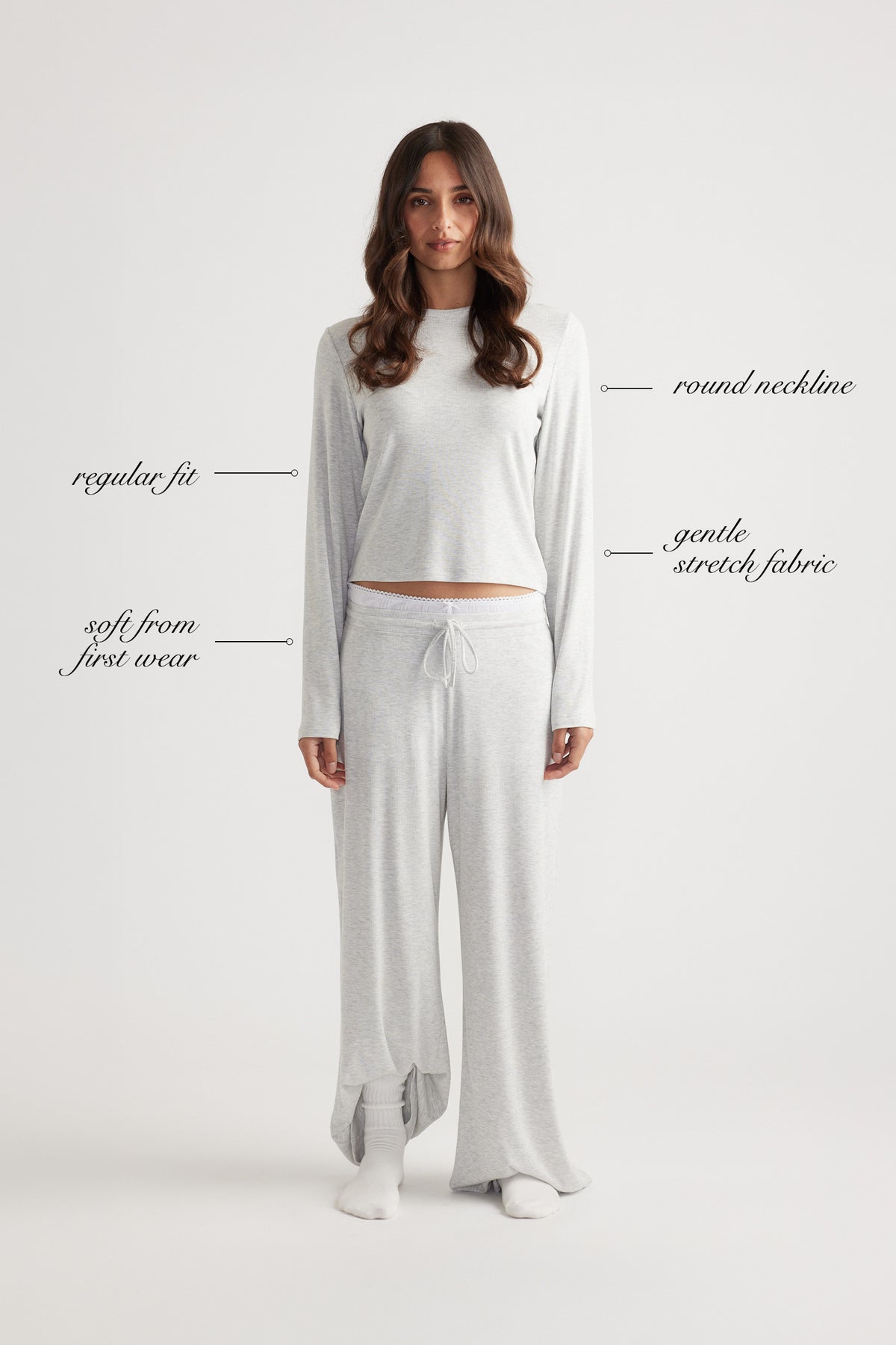 Woman wearing a light grey ribbed long sleeve top with round neckline and relaxed wide leg pants for laid-back comfort