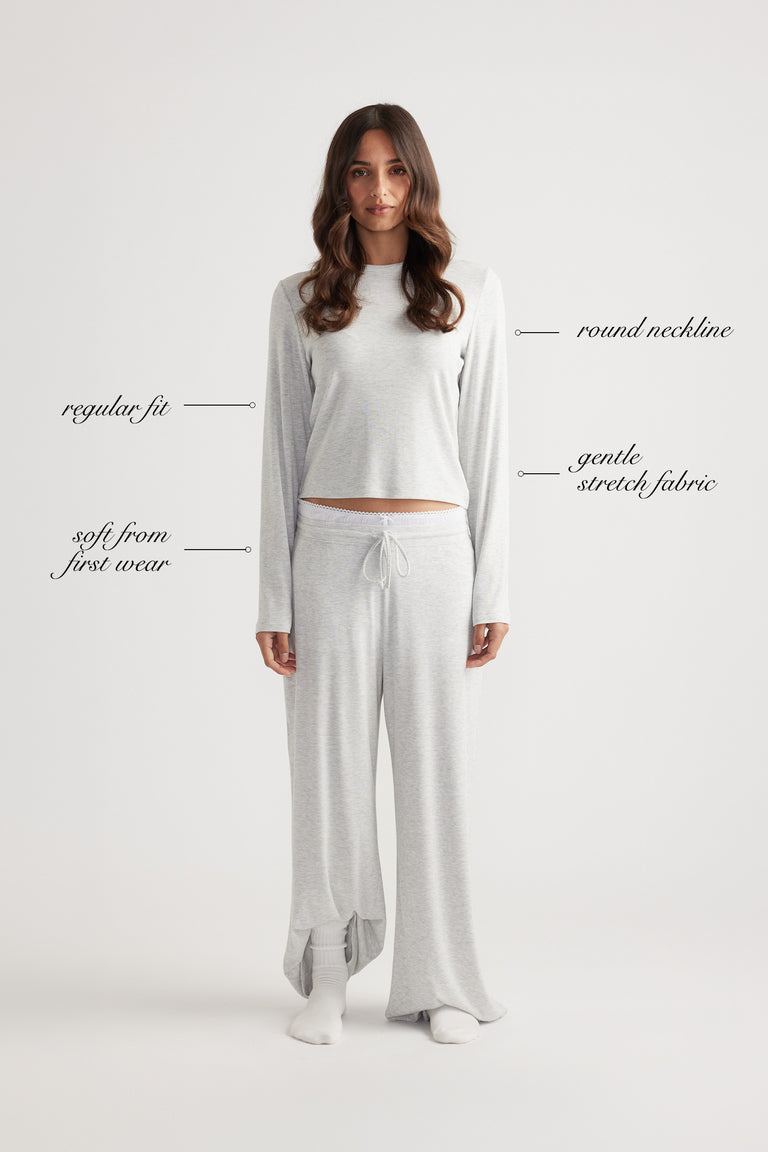 Woman wearing a light grey ribbed long sleeve top with round neckline and relaxed wide leg pants for laid-back comfort