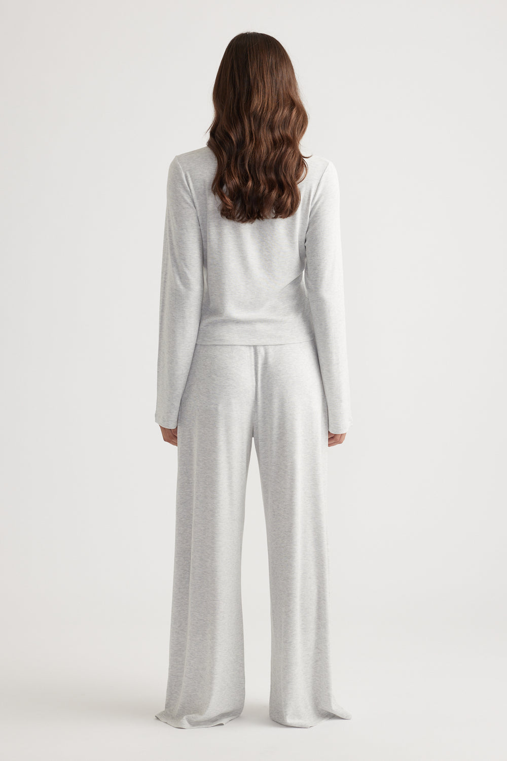 Woman wearing light grey ribbed long sleeve top paired with matching wide leg pants for relaxed loungewear style
