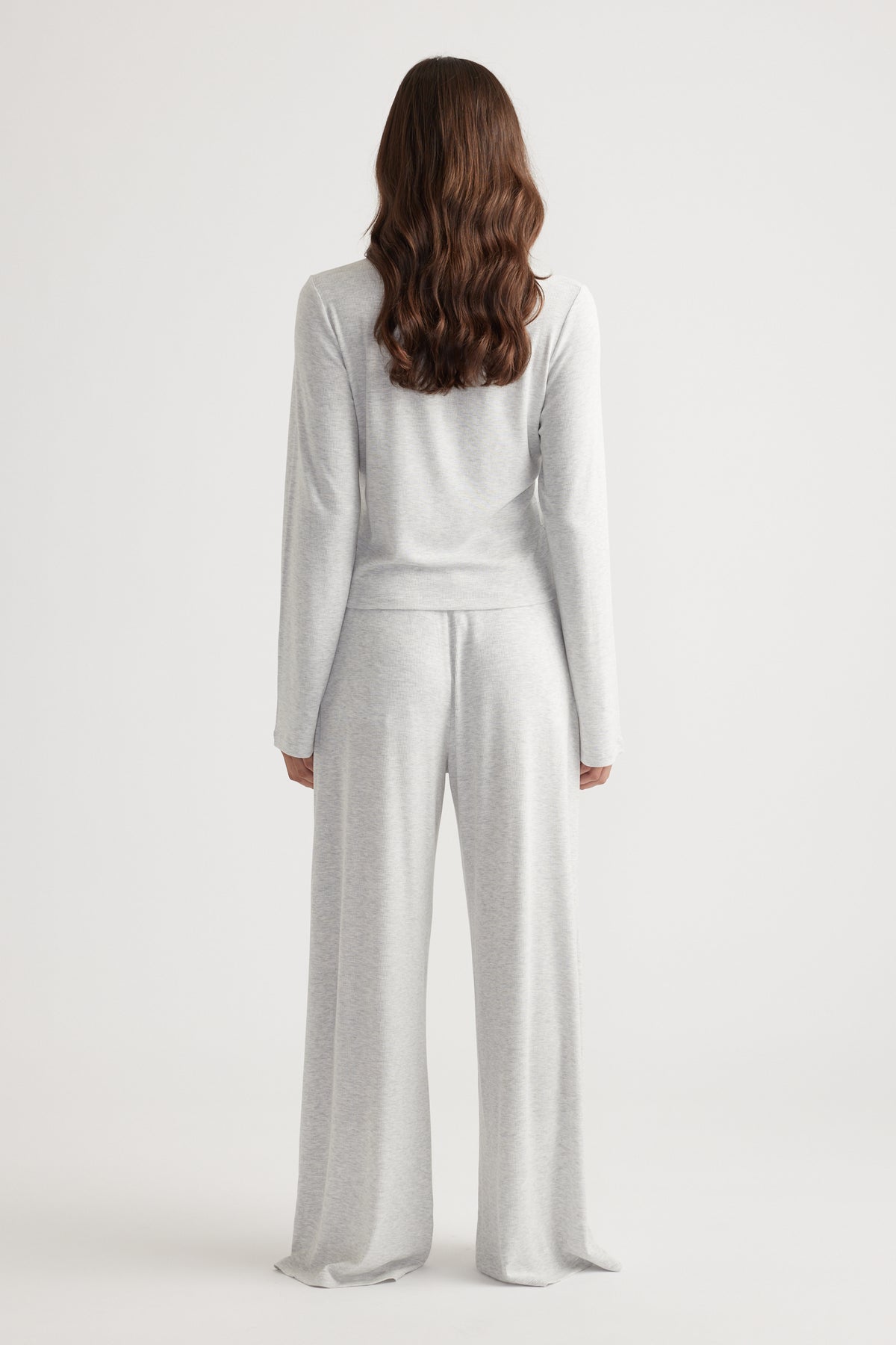 Woman wearing light grey ribbed long sleeve top paired with matching wide leg pants for relaxed loungewear style