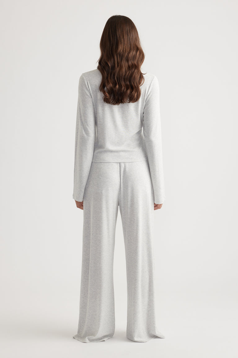 Woman wearing light grey ribbed long sleeve top paired with matching wide leg pants for relaxed loungewear style