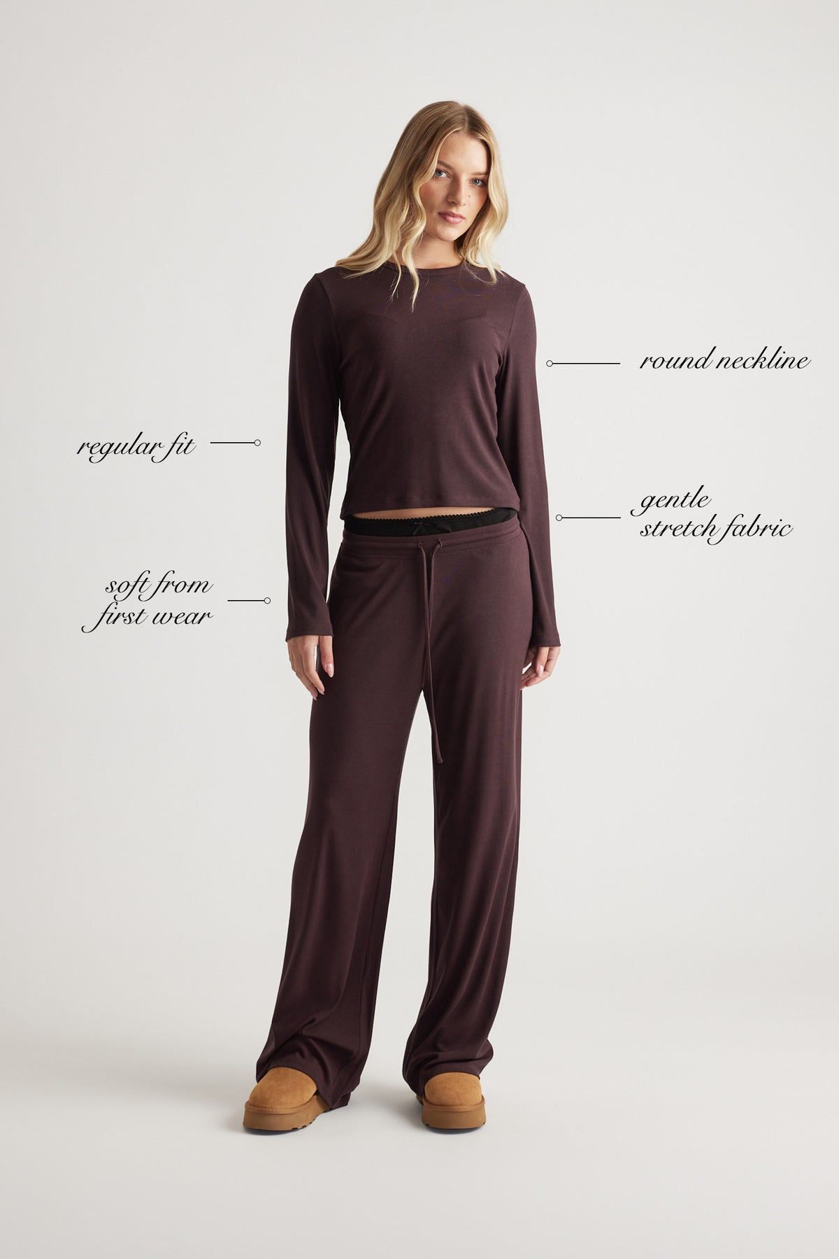 Woman wearing a soft ribbed long sleeve top with round neckline and relaxed fit in a warm rhubarb shade