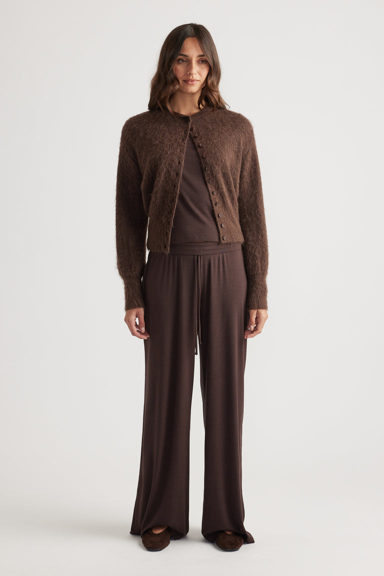 Woman wearing deep chocolate ribbed wide-leg pants paired with a fuzzy button-up cardigan and matching top