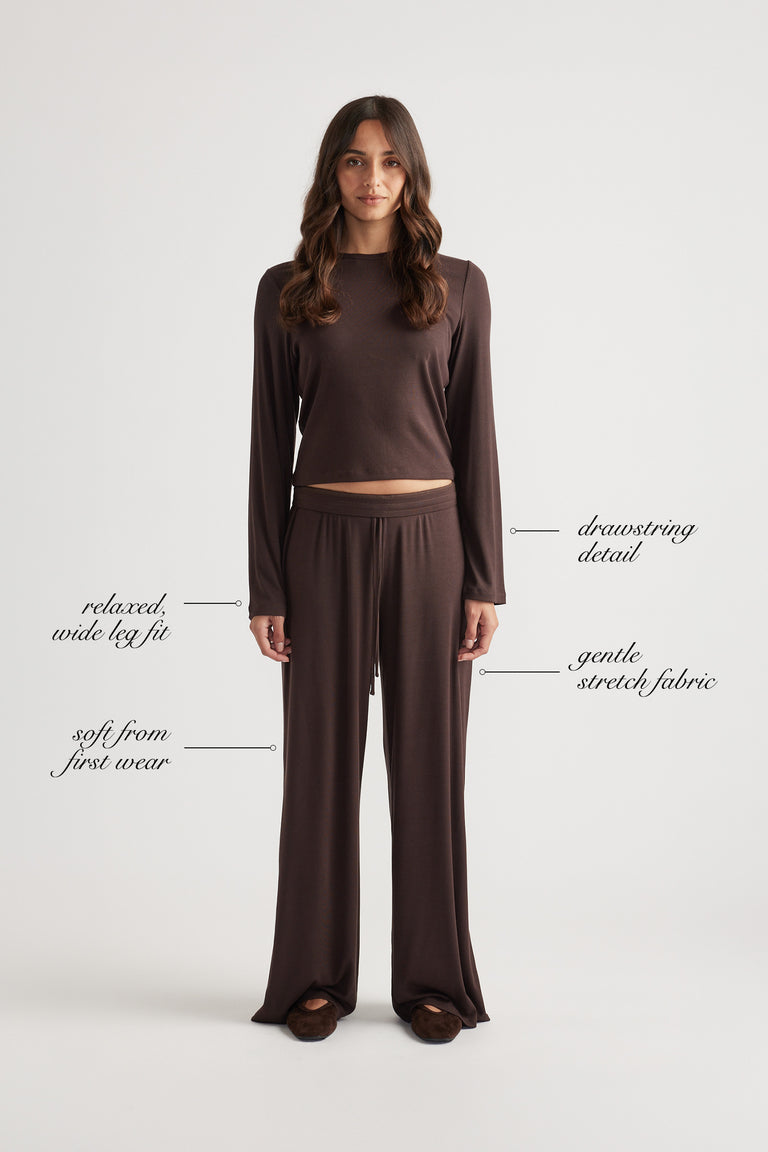 Woman in relaxed chocolate ribbed wide leg pants with drawstring waist and matching long sleeve top in soft stretch fabric