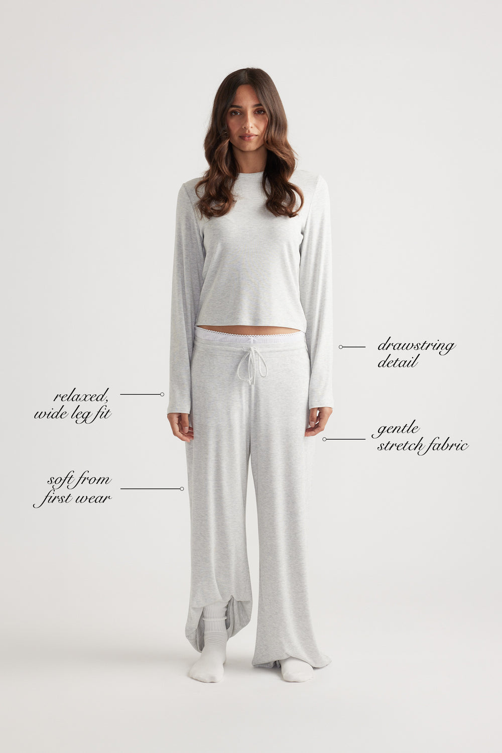 Woman wearing soft grey ribbed wide leg pants with drawstring waist and relaxed fit, paired with matching long sleeve top