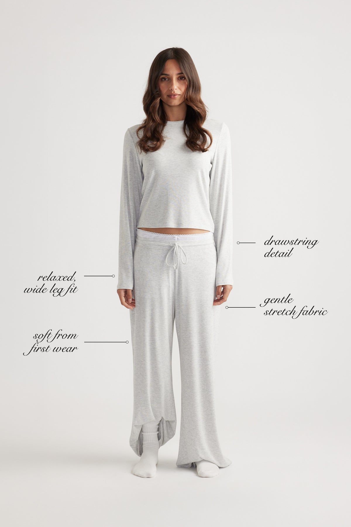 Woman wearing soft grey ribbed wide leg pants with drawstring waist and relaxed fit, paired with matching long sleeve top