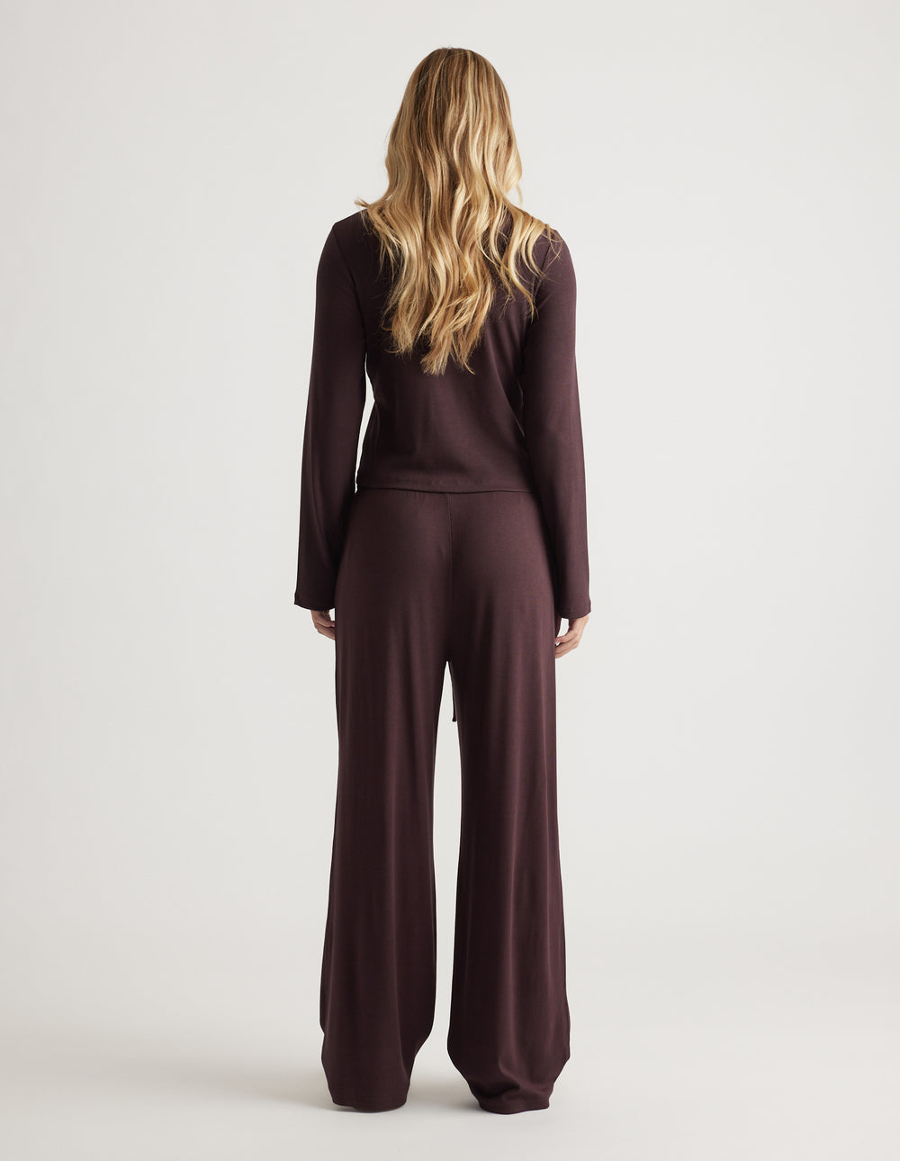 Back view of relaxed fit ribbed wide leg pant and matching long sleeve top in soft dark brown fabric