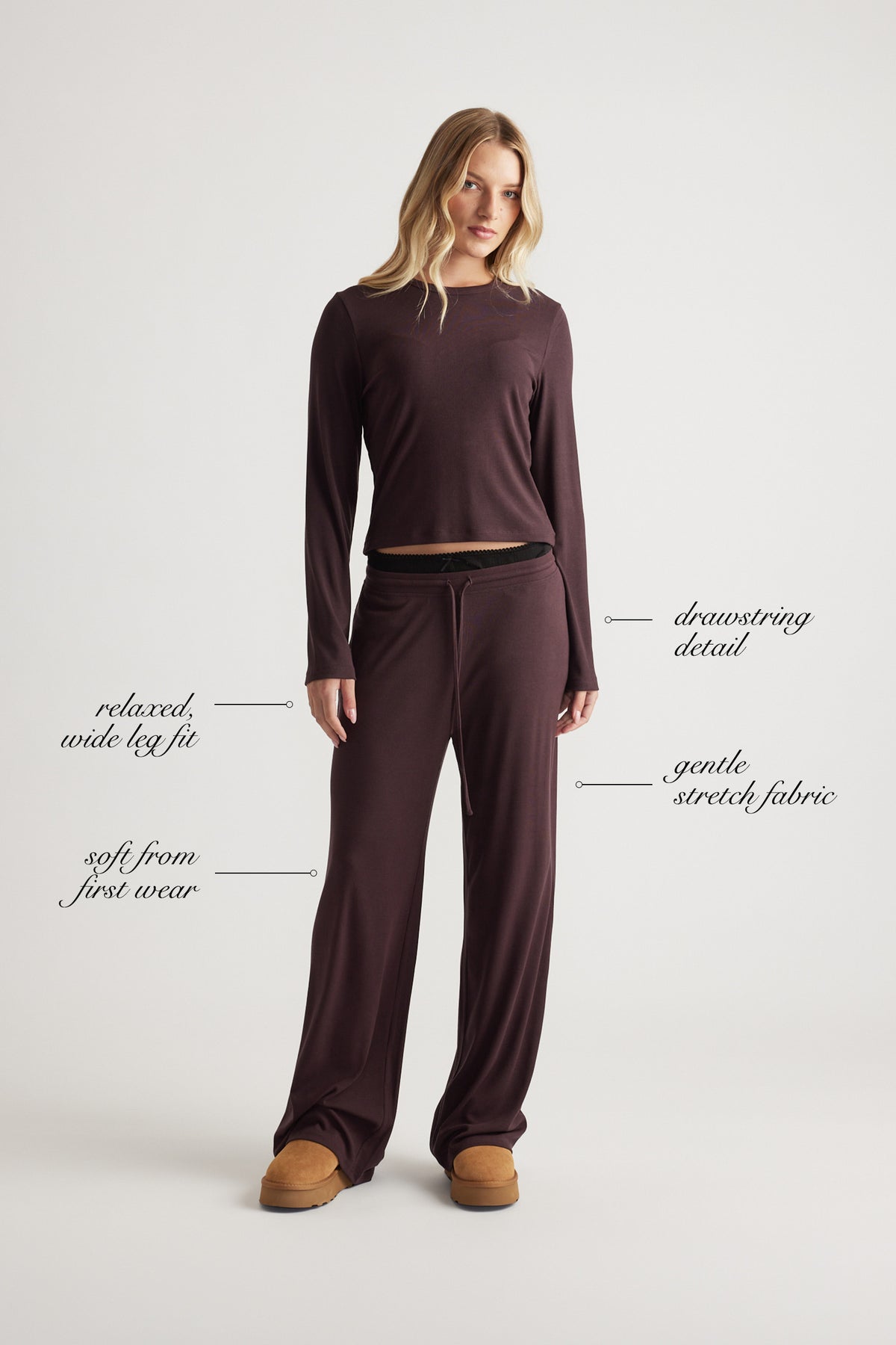 Woman wearing relaxed fit wide leg pants with a drawstring waist and soft stretch fabric in a rich rhubarb color