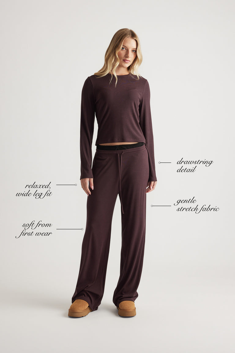 Woman wearing relaxed fit wide leg pants with a drawstring waist and soft stretch fabric in a rich rhubarb color